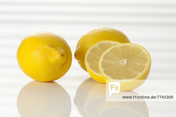 Ganze und halbierte frische Zitronen  Nahaufnahme