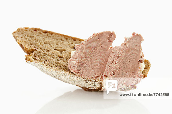 Gänseleberwurst mit Bauernbrot auf weißem Hintergrund Nahaufnahme