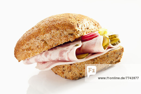 Sandwich aus Kornbrötchen mit Jagdwurst auf weißem Grund  Nahaufnahme