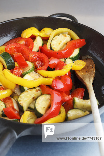 Fried zucchini pepper salad in frying pan