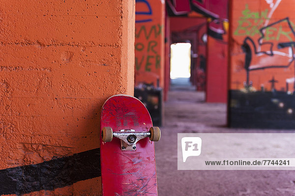Germany  North Rhine Westphalia  Duisburg  Skateboard against graffiti sprayed wall