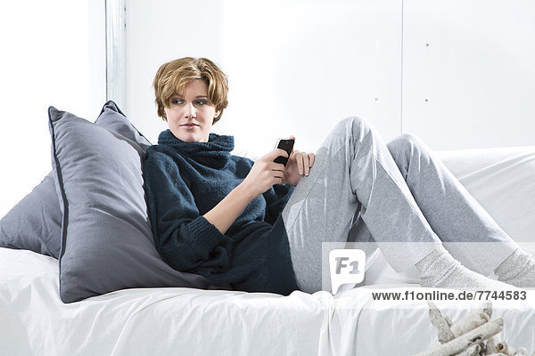 Young woman using mobile on couch