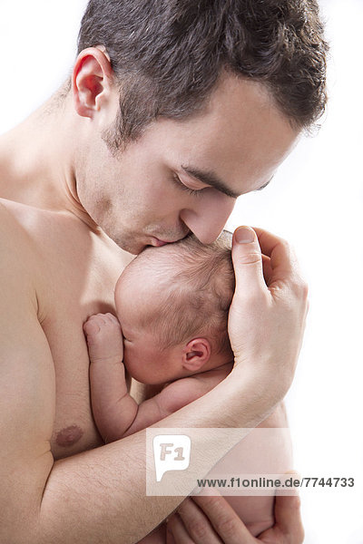 Father kissing son against white background  close up