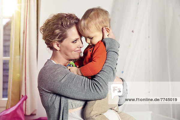 Deutschland  Bonn  Schwangere Mutter mit Sohn  lächelnd