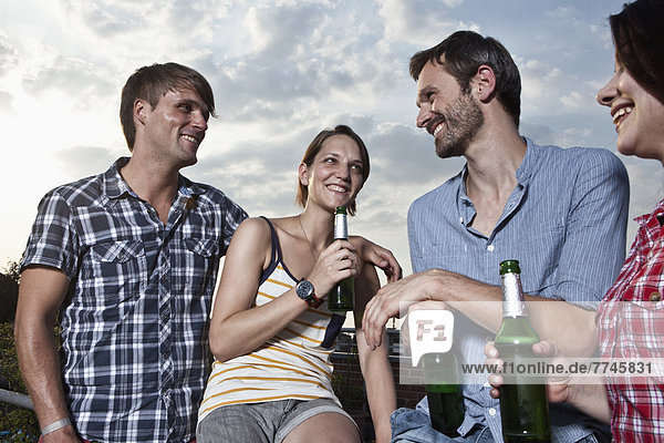 Men and women having fun on roof terrace  smiling