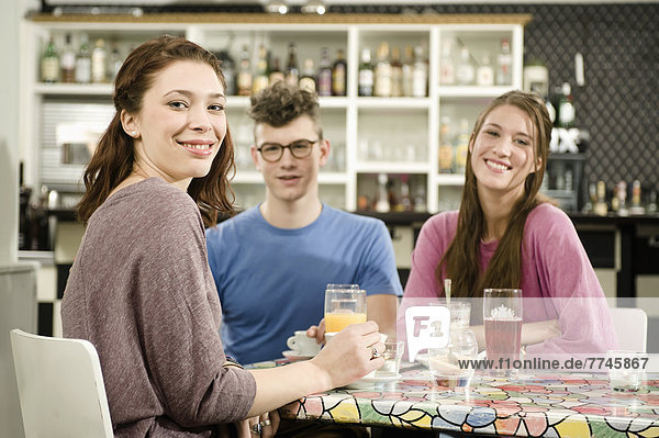 Deutschland  Bayern  München  Junge Freunde im Café  lächelnd  Portrait
