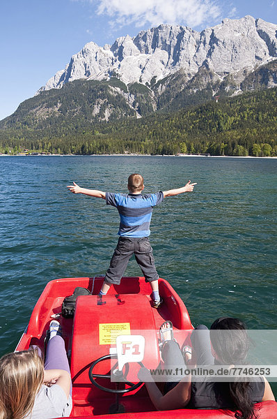 Germany  Bavaria  Family in paddleboat on Lake Eibsee with Wetterstein mountains in background