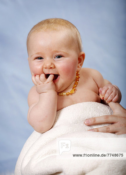 Baby  5 Monate  lacht  steckt Finger in den Mund