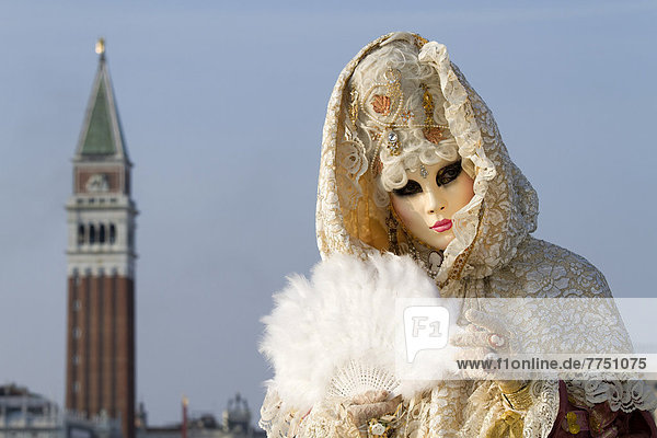 Carnival in Venice  Venetian mask and a fanciful costume  Campanile tower at back