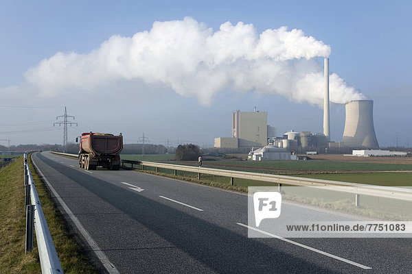 Lastwagen auf zweispuriger Schnellstraße vor rauchendem Kühlturm und Schornstein des Kohlekraftwerks Petershagen-Lahde