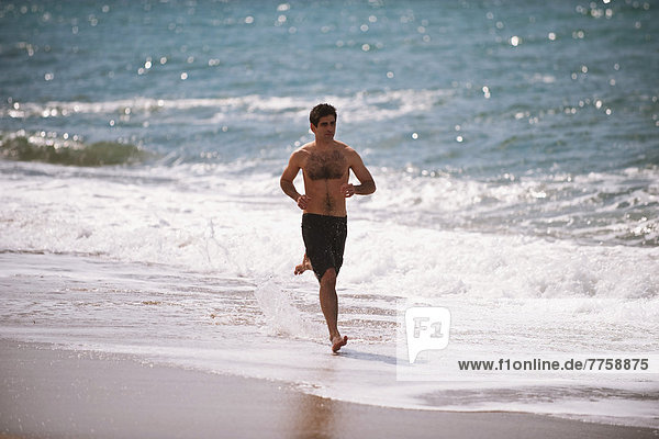 Young Man Running On The Beach