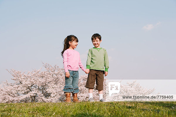 Children holding hands on grassland