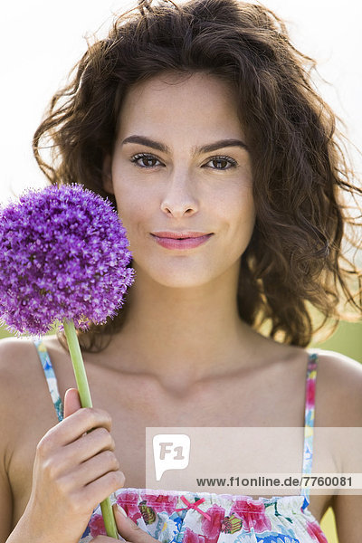 Porträt einer jungen Frau mit einer Blume
