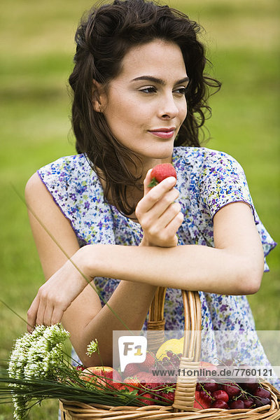 Junge Frau mit einem Korb voller Früchte