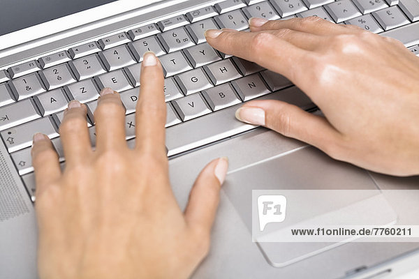 Woman's hands writting on a laptop