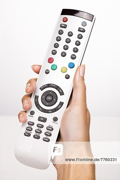 Woman's hand holding a remote control