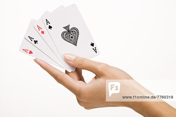 Frauenhand mit vier Spielkarten (Ass)