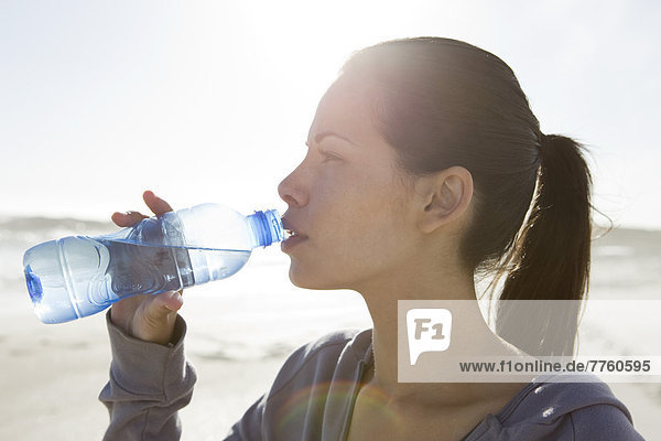 Junge Frau trinkt Wasser aus einer Flasche