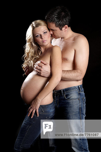 Mann umarmt oben ohne schwangere Frau