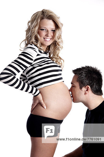 Mann küsst Bauch der schwangeren Frau