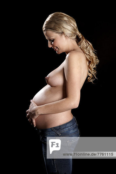 Oben-ohne schwangere Frau mit Händen auf dem Bauch