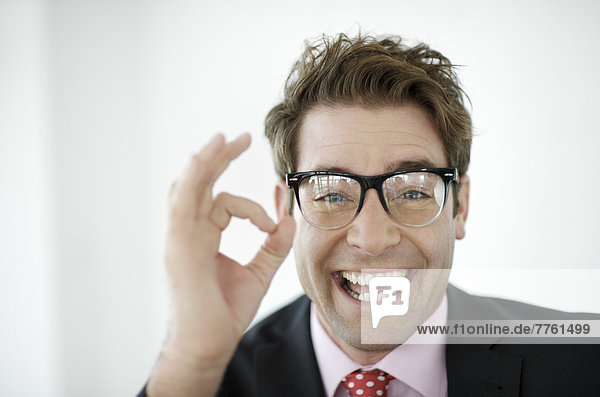 Portrait of smiling businessman doing OK gesture