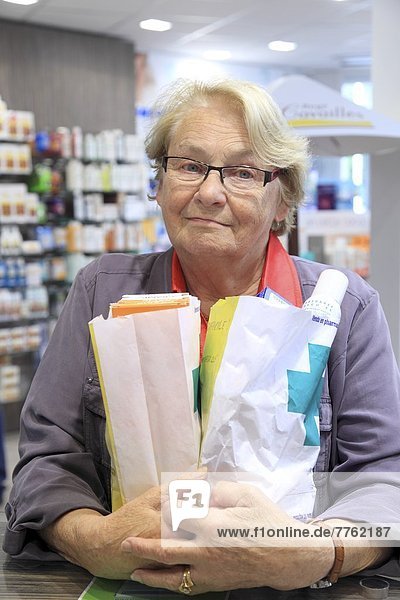 France  drugstore  senior woman with a lot of medicines