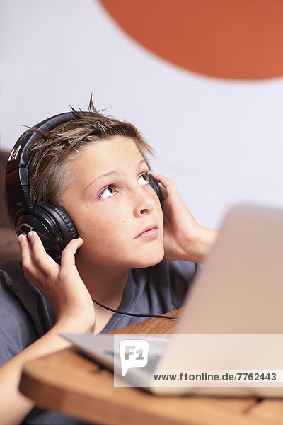 Frankreich  Junge  der mit dem Computer Musik hört.