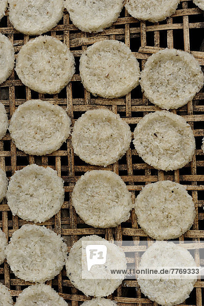 Runde Reiskuchen aus Klebreis trocknen auf einem Bambusgestell