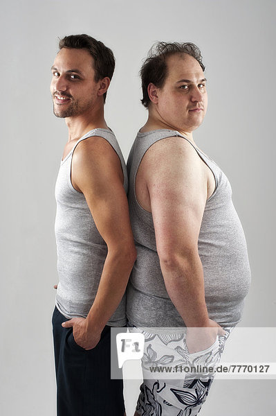 Sportlicher  muskulöser Mann und dicker Mann stehen Rücken an Rücken