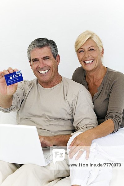 Erwachsenes Paar mit Laptop  Frau mit Kreditkarte