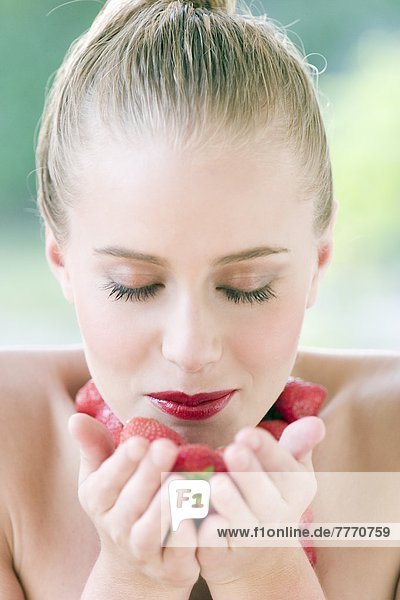 Porträt einer jungen Frau mit Erdbeeren