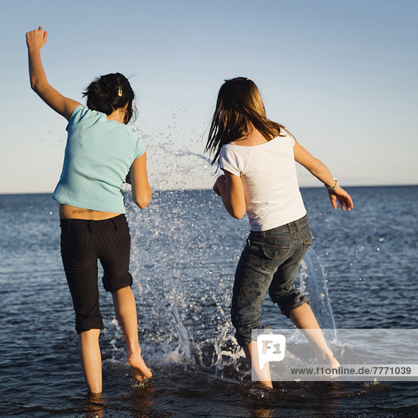 Two little girls playing in a lake
