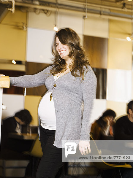 Smiling pregnant woman in restaurant