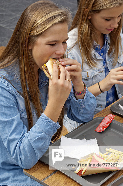 Teenagers eating an hamburger