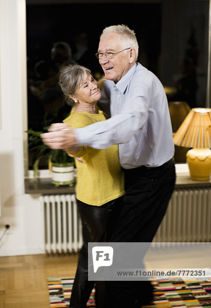Fröhliches Seniorenpaar tanzt zu Hause