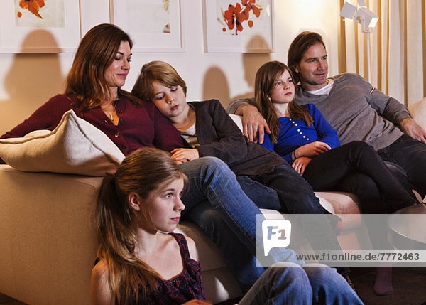 Fünfköpfige Familie beim Fernsehen im Wohnzimmer