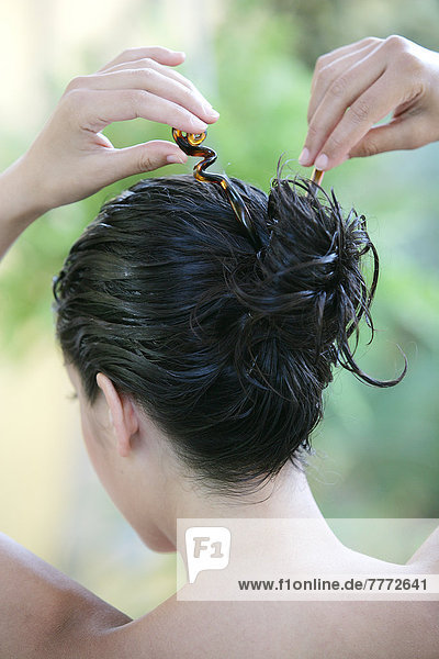 Portrait Frau beim Binden ihrer langen nassen braunen Haare  Haarpflegeprodukt