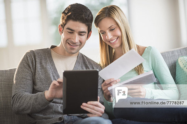 Couple using tablet pc to pay bills online
