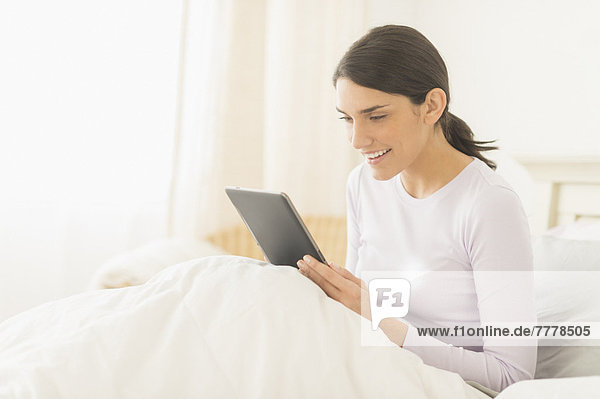 sitzend  benutzen  Frau  Bett  Tablet PC