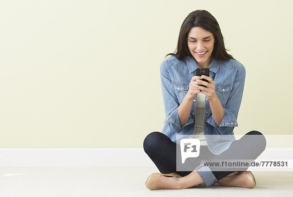 Handy  sitzend  benutzen  Frau  Boden  Fußboden  Fußböden
