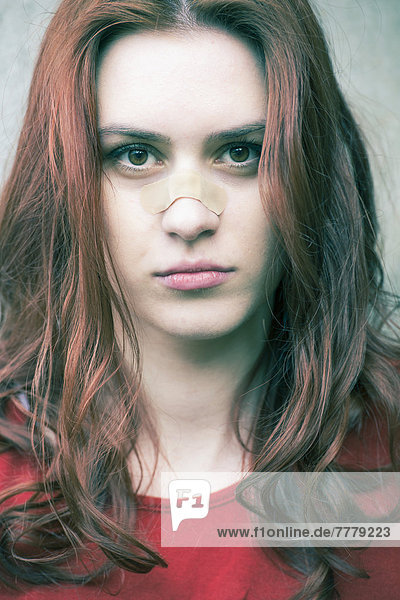Portrait of a young woman with a band-aid on her nose