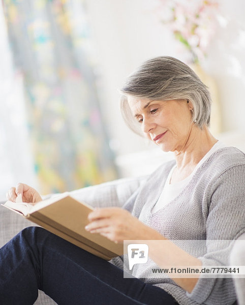 Portrait of woman reading on sofa