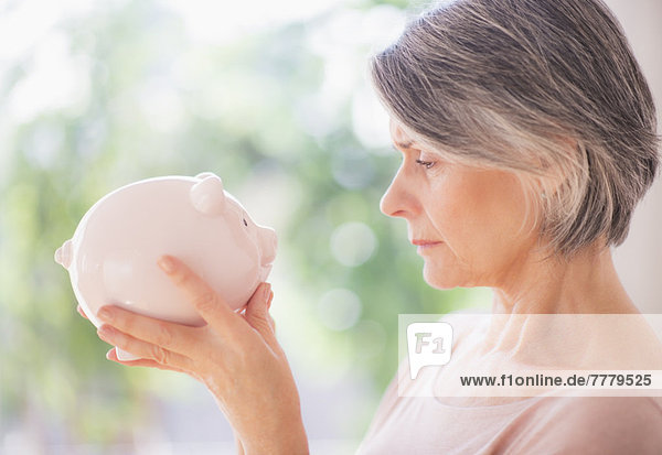 Portrait of woman holding piggy bank