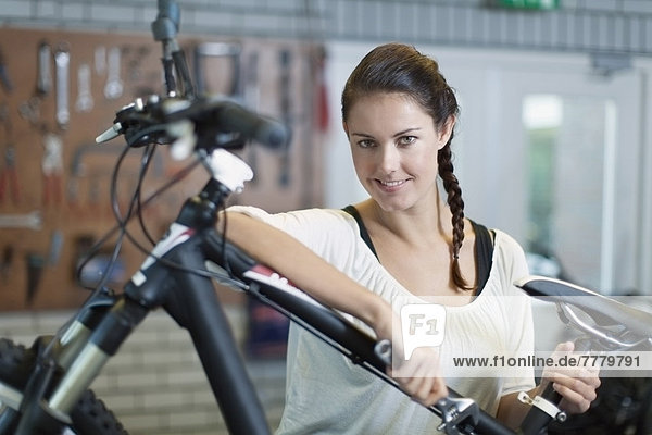 Woman with bicycle in workshop