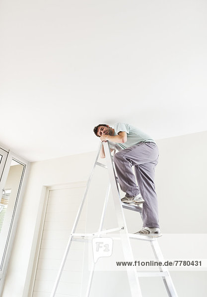 Mann klettert Leiter im Haus