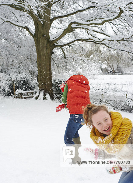 Mutter und Tochter spielen im Schnee