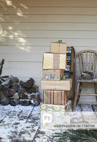 Stapel Weihnachtsgeschenke auf verschneiter Terrasse