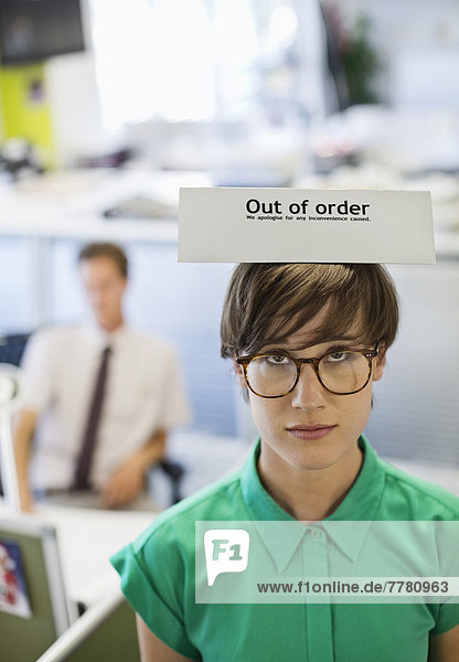 Geschäftsfrau trägt das Zeichen'out of order'.