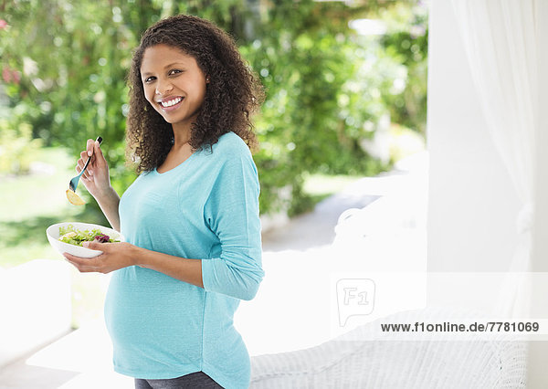 Schwangere Frau isst Salat